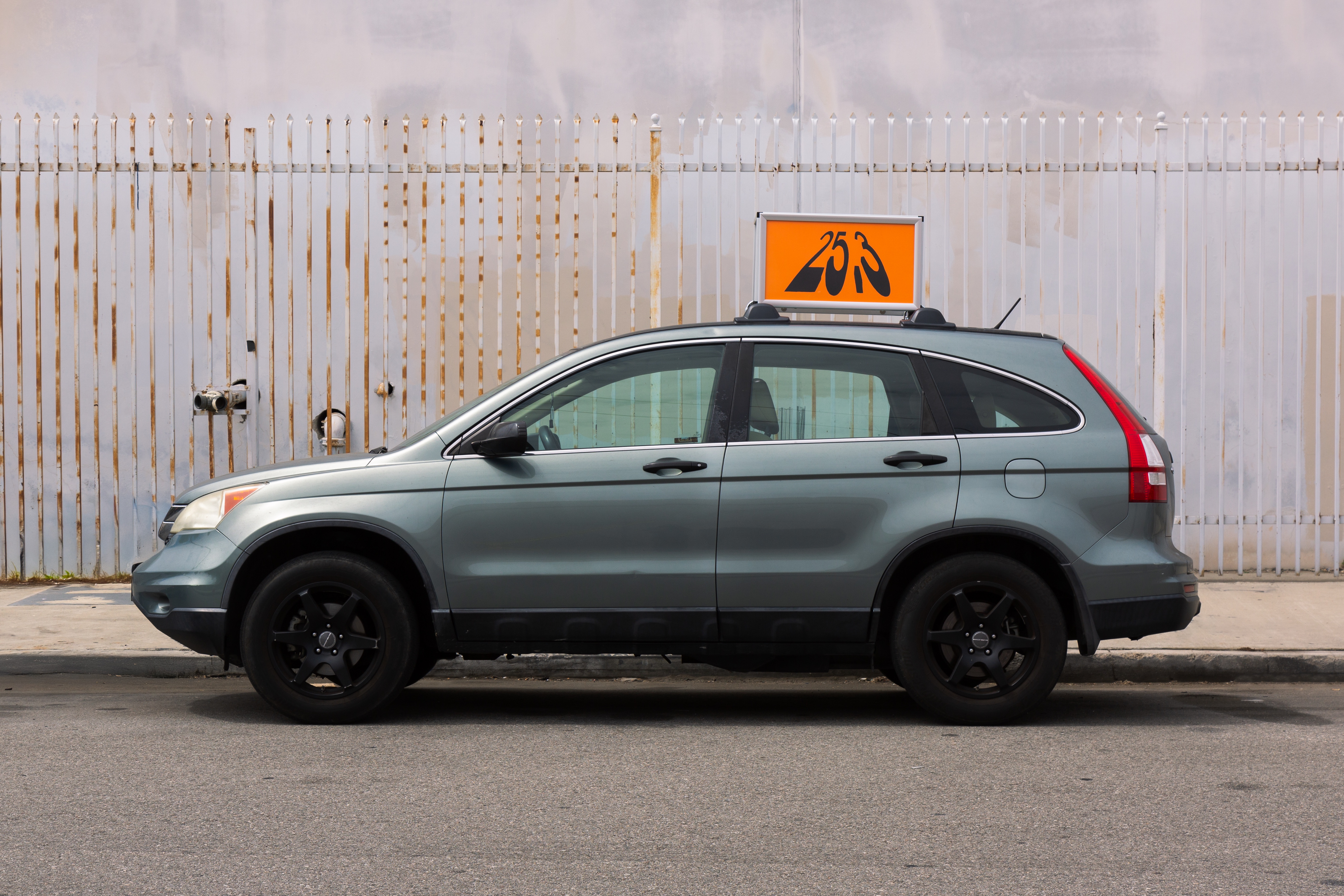 The Gallery 25.3 car parked in front of a white metal fence